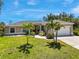 Charming single-story home featuring a well-manicured lawn, beautiful landscaping, and a two-car garage at 1298 Russellville St, North Port, FL 34288