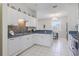 Charming kitchen with white cabinetry, colorful backsplash, and stainless steel appliances at 1298 Russellville St, North Port, FL 34288