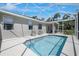 Screened-in pool with ample deck space and seating surrounded by lush greenery at 1298 Russellville St, North Port, FL 34288