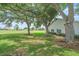 Expansive green backyard featuring mature trees and golf course views at 1432 Colony Pl, Venice, FL 34292