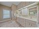Bright bathroom featuring dual sinks, spacious countertop, cabinets, and a window for natural light at 1432 Colony Pl, Venice, FL 34292