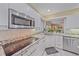 Stylish kitchen featuring white cabinetry, granite countertops, and modern appliances at 1432 Colony Pl, Venice, FL 34292