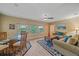 Comfortable living room with large windows, ceiling fan, hardwood floor, and a cozy seating area at 1432 Colony Pl, Venice, FL 34292