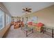 Bright living room with comfortable seating, a ceiling fan, and views through large windows at 1432 Colony Pl, Venice, FL 34292