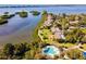 Stunning aerial view of waterfront property with community pool and lush landscaping near the water at 1629 Pelican Cove Rd # 138A, Sarasota, FL 34231