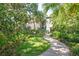 Condo building surrounded by lush landscaping, inviting walkway and mature trees at 1629 Pelican Cove Rd # 138A, Sarasota, FL 34231