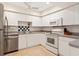 Well-lit kitchen with white appliances, ample counter space, and neutral accents at 1629 Pelican Cove Rd # 138A, Sarasota, FL 34231