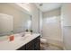 Bathroom featuring dark vanity, large mirror, tiled shower-tub, and plant; enjoy this bathroom with lots of light at 1739 Lake Verona Cir, Bradenton, FL 34211