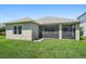 Rear exterior view of the home featuring a screened-in lanai and a spacious backyard at 1739 Lake Verona Cir, Bradenton, FL 34211