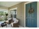 Inviting front porch featuring two chairs, a small table, and a beautifully decorated front door with a wreath at 1739 Lake Verona Cir, Bradenton, FL 34211