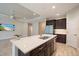 Open kitchen showcasing a large island, stainless steel appliances, dark wood cabinets, and recessed lighting at 1739 Lake Verona Cir, Bradenton, FL 34211