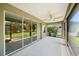 View of the covered patio with ceiling fan, sliding glass doors, and backyard at 1739 Lake Verona Cir, Bradenton, FL 34211