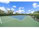Outdoor tennis court surrounded by well-maintained landscaping and blue skies at 1739 Lake Verona Cir, Bradenton, FL 34211
