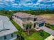 An aerial view of a two-story home with well-kept landscaping, a brick driveway, and a beautiful lake view at 17904 Palmiste Dr, Bradenton, FL 34202