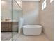 This serene bathroom includes a soaking tub, glass enclosed shower and modern fixtures at 17904 Palmiste Dr, Bradenton, FL 34202
