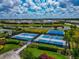 An aerial view of community tennis and basketball courts surrounded by beautiful landscaping and a serene lake at 17904 Palmiste Dr, Bradenton, FL 34202
