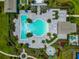 Aerial view of a community pool with lounge chairs surrounded by lush landscaping at 17904 Palmiste Dr, Bradenton, FL 34202