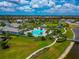 Aerial view of community pool, clubhouse, and playground next to a lake at 17904 Palmiste Dr, Bradenton, FL 34202