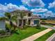 Inviting two-story home featuring lush landscaping, a paver driveway, and a charming front porch at 17904 Palmiste Dr, Bradenton, FL 34202