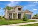 Charming two-story home showcasing a well-manicured lawn, covered porch, and an attached two-car garage at 17904 Palmiste Dr, Bradenton, FL 34202
