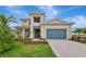 Beautiful two-story home showcasing a blue garage door, lush landscaping, and a manicured lawn at 17904 Palmiste Dr, Bradenton, FL 34202