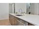 Close-up of kitchen island featuring a sink, quartz countertop, and view to the entryway staircase at 17904 Palmiste Dr, Bradenton, FL 34202
