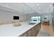 Spacious kitchen island featuring a sink, quartz countertop, and view to a dining area and outdoor pool at 17904 Palmiste Dr, Bradenton, FL 34202