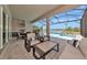 Inviting outdoor lanai with comfortable seating, an outdoor kitchen, and a stunning pool and water view at 17904 Palmiste Dr, Bradenton, FL 34202