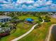 Aerial view of community playground with shade next to a lake with walking trail at 17904 Palmiste Dr, Bradenton, FL 34202