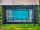 Aerial view of a screened-in pool and spa area with lush green grass, surrounded by tropical landscaping at 17904 Palmiste Dr, Bradenton, FL 34202