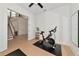 Minimalist workout room featuring a peloton bike, mirrors, and a view to the staircase at 17904 Palmiste Dr, Bradenton, FL 34202