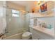 Bright bathroom features tiled shower-tub combo with glass doors, white wainscoting, and a modern vanity at 205 71St St # B, Holmes Beach, FL 34217