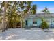 Inviting single-story home with a light-blue exterior, quaint porch, and a beautifully landscaped yard filled with tropical plants at 205 71St St # B, Holmes Beach, FL 34217