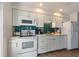 Modern kitchen with sleek white cabinets, blue backsplash, and updated appliances for a clean and stylish cooking space at 205 71St St # B, Holmes Beach, FL 34217