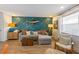Bright living room featuring a gray sectional, unique wallpaper with fish accents, and plenty of natural light at 205 71St St # B, Holmes Beach, FL 34217