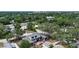 Aerial view of a two-story home surrounded by mature trees and lush greenery in a suburban neighborhood at 2485 S Milmar Dr, Sarasota, FL 34237