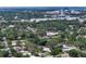 Aerial view of a suburban home surrounded by lush greenery and nearby city buildings on the horizon at 2485 S Milmar Dr, Sarasota, FL 34237