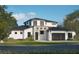 Beautiful two-story home featuring a stone facade, black trim windows, manicured lawn and dark garage door at 2485 S Milmar Dr, Sarasota, FL 34237