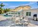Outdoor patio area with lounge chairs and umbrellas by the pool at 306 68Th St, Holmes Beach, FL 34217