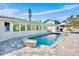 Backyard pool with stone patio and lounge chairs, and partial exterior view of the home at 306 68Th St, Holmes Beach, FL 34217