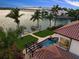 Captivating aerial view highlights a waterfront property with a pool, private dock, and stunning tropical landscaping at 3576 San Remo Ter, Sarasota, FL 34239