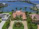 Panoramic aerial view showcases a waterfront estate with mature landscaping, circular driveway, and stunning architectural design at 3576 San Remo Ter, Sarasota, FL 34239
