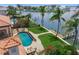Aerial view of the private backyard pool and dock on the intercoastal waterway with palm trees and outdoor dining at 3576 San Remo Ter, Sarasota, FL 34239