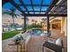 Inviting backyard with a pool, a covered patio and lush landscaping overlooking the water at 3576 San Remo Ter, Sarasota, FL 34239