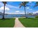 Landscaped backyard with a paver path leading to a private dock on the intercoastal waterway at 3576 San Remo Ter, Sarasota, FL 34239