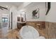 Elegant bathroom with stone floors, soaking tub, and custom dark wood vanity at 3576 San Remo Ter, Sarasota, FL 34239