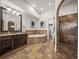 Elegant bathroom with stone floors, walk-in shower, soaking tub, and custom dark wood vanity at 3576 San Remo Ter, Sarasota, FL 34239
