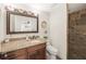 Well-lit bathroom featuring granite countertop vanity, a toilet, and a tiled walk-in shower at 3576 San Remo Ter, Sarasota, FL 34239