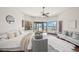 Bright primary bedroom with water views, hardwood floors, ceiling fan, and comfortable seating at 3576 San Remo Ter, Sarasota, FL 34239