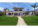 Beautiful two-story waterfront estate with an outdoor dining area and pergola covered seating area at 3576 San Remo Ter, Sarasota, FL 34239